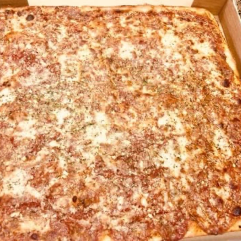 A large, rectangular Pizza Village V pizza with melted cheese and tomato sauce in a cardboard box.