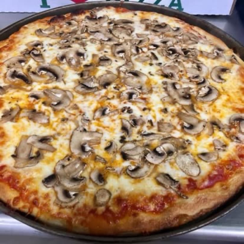 A large, freshly baked mushroom pizza from Pizza Village V, with melted cheese and a golden crust.